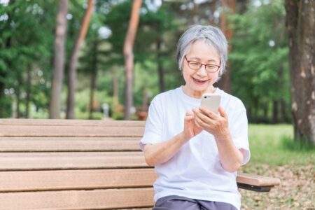 公園でスマホを見る老人